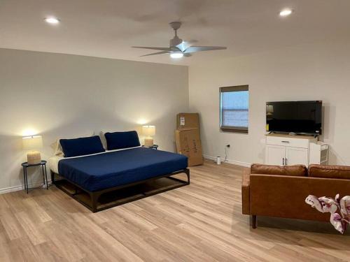 um quarto com uma cama azul e um sofá em Ranchette Apartment- beach access small lake view em Buchanan Dam