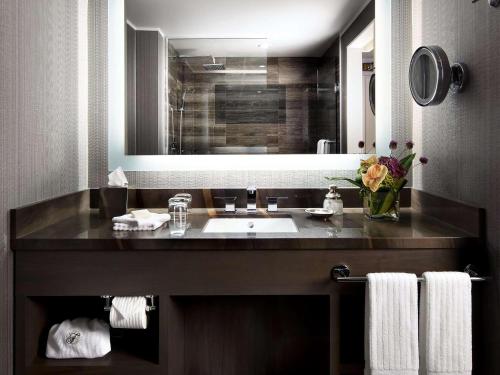 a bathroom with a sink and a large mirror at Fairmont Waterfront in Vancouver