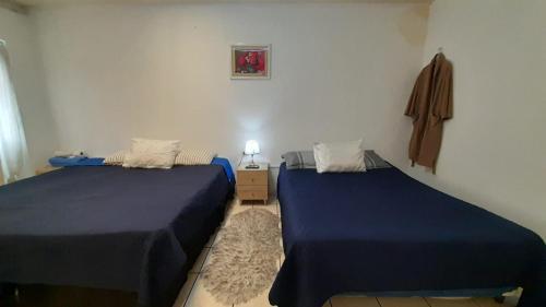 Hotel Bluehouse في غواتيمالا: سريرين في غرفة ذات أغطية زرقاء