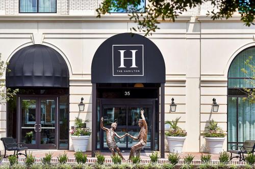 阿爾法利塔的住宿－The Hamilton Alpharetta, Curio Collection By Hilton，两座建筑前方的雕像