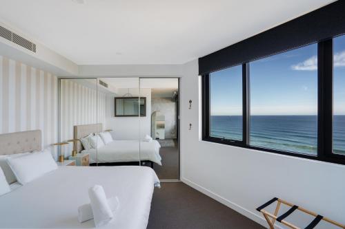 a bedroom with a view of the ocean at 603 Newcastle Beachfront Apartment in Newcastle