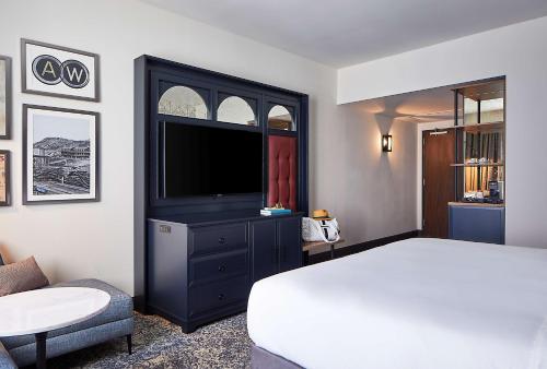 a bedroom with a bed and a flat screen tv at The Hamilton Alpharetta, Curio Collection By Hilton in Alpharetta