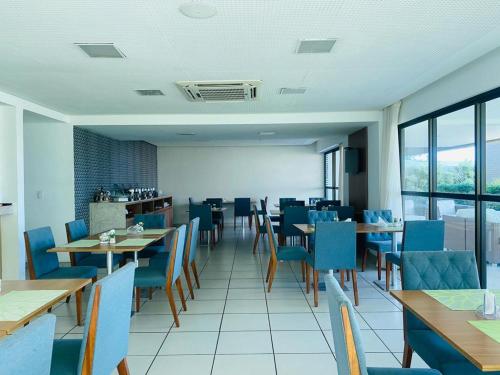 une salle à manger avec des tables et des chaises bleues dans l'établissement FLAT EXCELSIOR- PRÓXIMO SHOPPING RIOMAR, à Récife