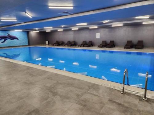 een groot zwembad in een gebouw met stoelen bij TOYA Next Residence in Istanbul