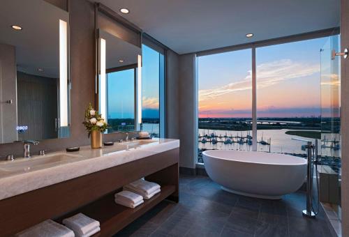 貝敦的住宿－Hyatt Regency Baytown-Houston，一间带大浴缸和大窗户的浴室