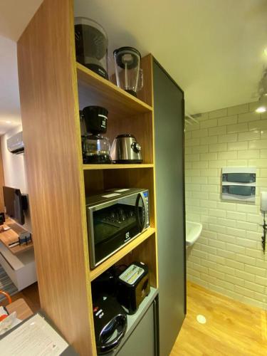 a kitchen with a shelf with a toaster and a microwave at FLAT EXCELSIOR- PRÓXIMO SHOPPING RIOMAR in Recife