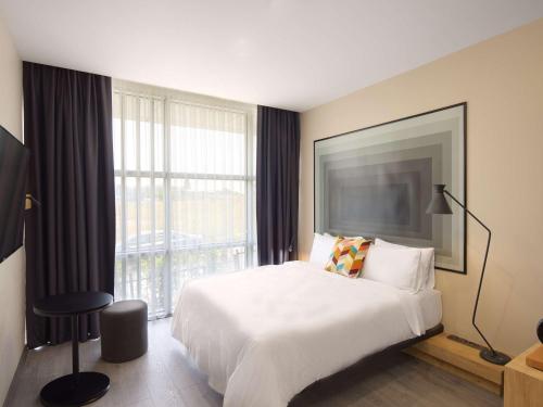 a hotel room with a bed and a large window at Ibis Istanbul Airport in Istanbul