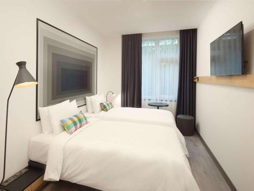 a white bedroom with a large white bed and a window at Ibis Istanbul Airport in Istanbul
