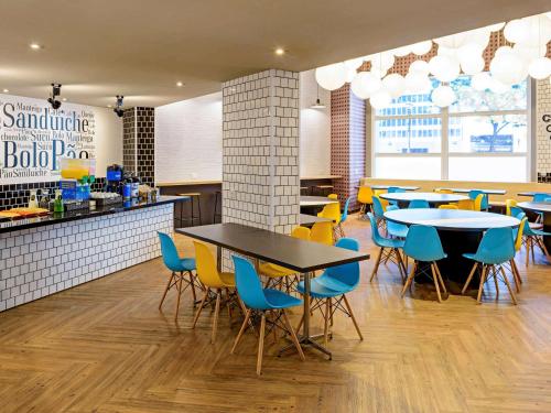 a restaurant with tables and chairs and a bar at ibis budget SP Centro Sao Joao in Sao Paulo