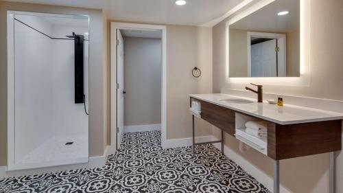 a bathroom with a sink and a mirror at The Hub Murray Hill, BW Premier Collection in New Providence