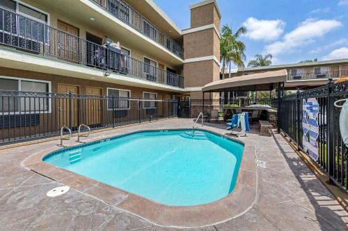 a swimming pool in front of a apartment building at Quality Inn & Suites Anaheim Maingate in Anaheim