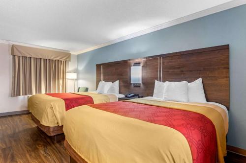 a hotel room with two beds with yellow and red sheets at Econo Lodge Byron - Warner Robins in Byron