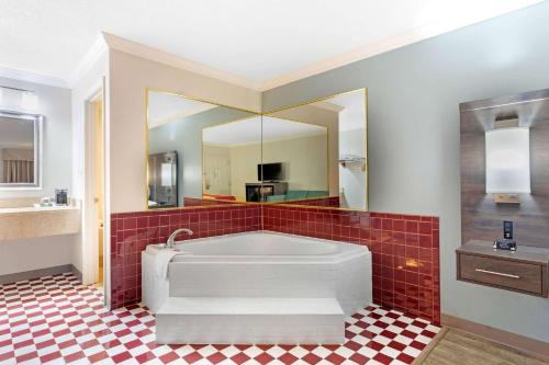 a large bathroom with a tub and a red tile floor at Econo Lodge Byron - Warner Robins in Byron