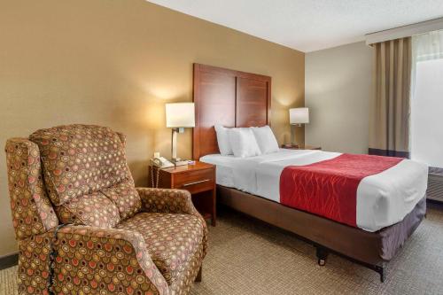 a hotel room with a bed and a chair at Comfort Inn & Suites in Rapid City