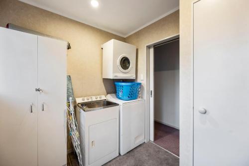 a small kitchen with a sink and a microwave at Hoani Honey - Kuratau Holiday Home in Kuratau