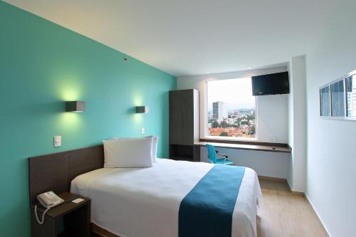 a hotel room with a bed and a window at One Periferico Sur in Mexico City