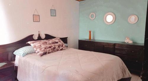 a bedroom with a bed and a dresser and mirrors at Casa Celeste in Morelia