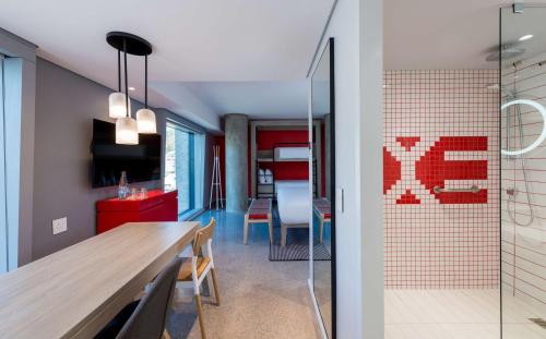 a kitchen and dining room with a table and a glass door at Radisson RED Hotel V&A Waterfront Cape Town in Cape Town