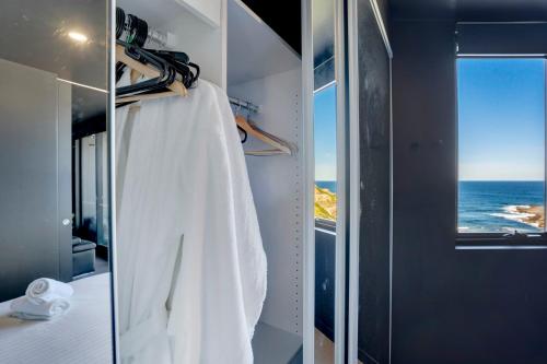 a room with a closet with a view of the ocean at 703 Luxury Ocean View Apartment in Newcastle