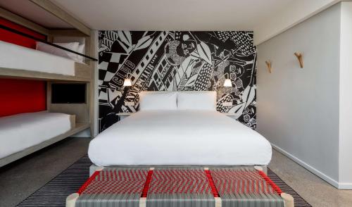 a bedroom with a large white bed and a black and white wall at Radisson RED Hotel V&A Waterfront Cape Town in Cape Town