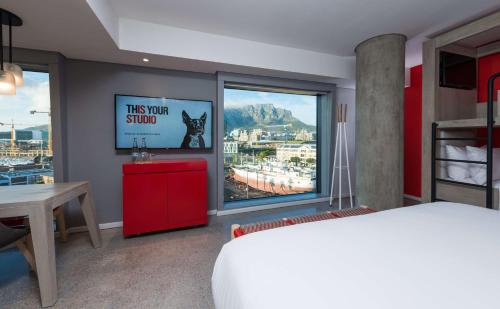 a bedroom with a bed and a window with a view at Radisson RED Hotel V&A Waterfront Cape Town in Cape Town