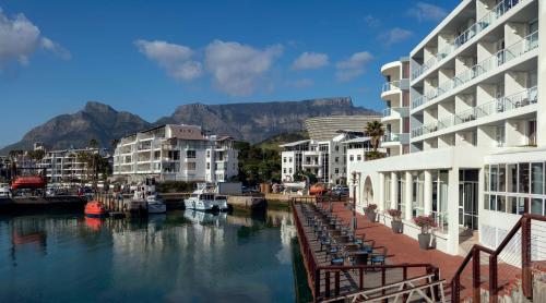 een jachthaven met gebouwen en een rivier met boten bij Radisson Blu Hotel Waterfront, Cape Town in Kaapstad