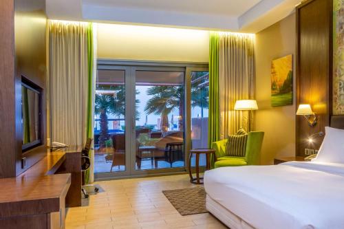 een hotelkamer met een bed en uitzicht op een patio bij Radisson Blu Hotel & Resort, Sohar in Sohar