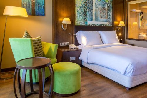 a hotel room with a bed and a table and chairs at Radisson Blu Hotel & Resort, Sohar in Sohar