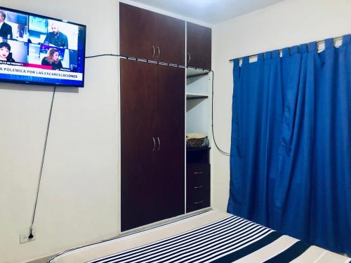 una camera da letto con TV e letto con tenda blu di Anita depto Jujuy a San Salvador de Jujuy