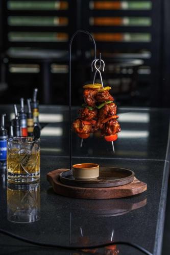 a rack of chicken on a stand next to a drink at Radisson Blu Hotel & Resort, Sohar in Sohar