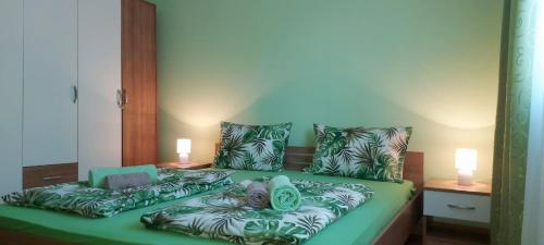 um quarto com uma cama verde com almofadas em Apartman ,,Milica'' em Donji Milanovac