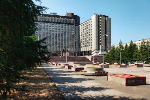 una fila de bancos frente a un gran edificio en Park Inn by Radisson Pribaltiyskaya Hotel and Congress Centre en San Petersburgo