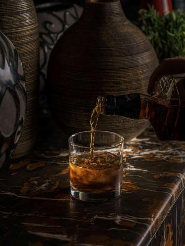a person is pouring a drink into a glass at Golden Tulip Muscat in Muscat