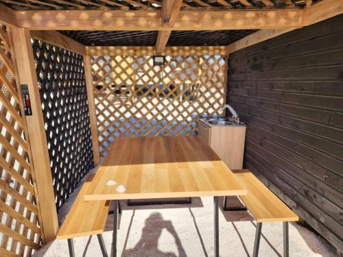 una mesa de madera en una sauna con un banco en Refugios del Mar, en Punta de Choros