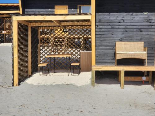een patio met een tafel en stoelen op het strand bij Refugios del Mar in Punta de Choros