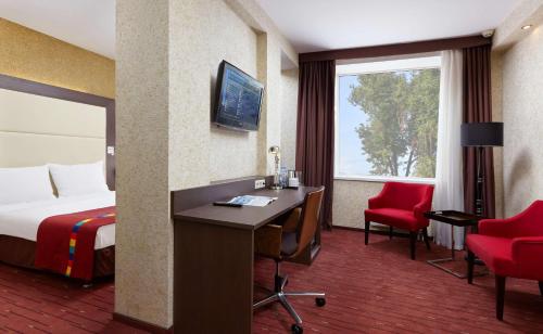 a hotel room with a bed and a desk with a computer at Park Inn by Radisson Odintsovo in Odintsovo