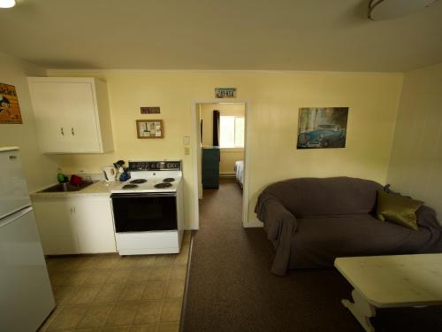 cocina y sala de estar con sofá en Creston Valley Motel, en Creston