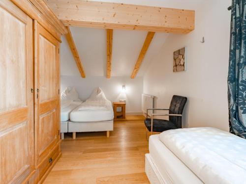 - une chambre avec un lit et une chaise dans l'établissement Brixen 1, à Brixen im Thale