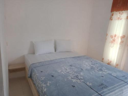 um pequeno quarto com uma cama azul num quarto em Gangga Guest House Bromo em Ngadisari