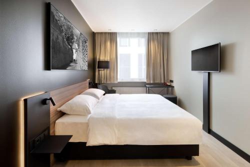 a bedroom with a large white bed and a television at Park Inn by Radisson Central Tallinn in Tallinn
