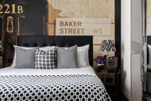 - une chambre avec un lit noir et blanc et des oreillers dans l'établissement Holmes Hotel London, à Londres