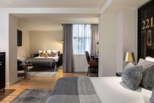 a hotel room with a bed and a couch at Holmes Hotel London in London