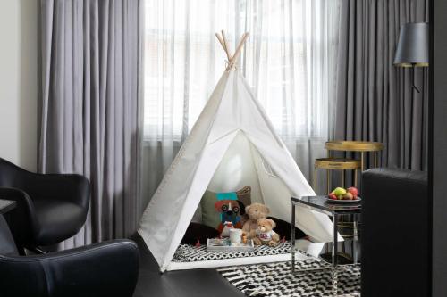 a white teepee tent in a living room at Holmes Hotel London in London