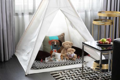 a toy tent with a dog and teddy bears in it at Holmes Hotel London in London