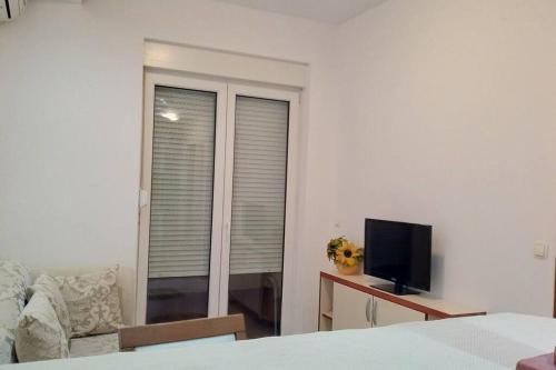 um quarto com uma janela com um sofá e uma televisão em Kotor Sveti Stasije Mila em Dobrota