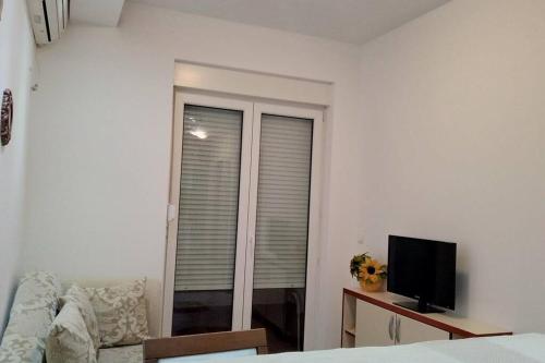 a living room with a couch and a tv and a window at Kotor Sveti Stasije Mila in Dobrota