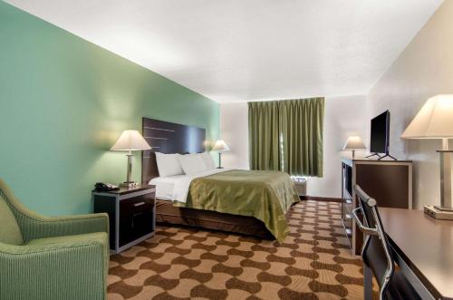 Habitación de hotel con cama y silla en Quality Inn en Russell