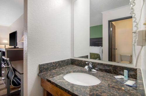 a bathroom with a sink and a large mirror at Quality Inn in Russell