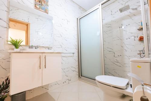 タンジェにあるluxe appartement malabata Tangerのトイレとガラスのシャワー付きのバスルーム