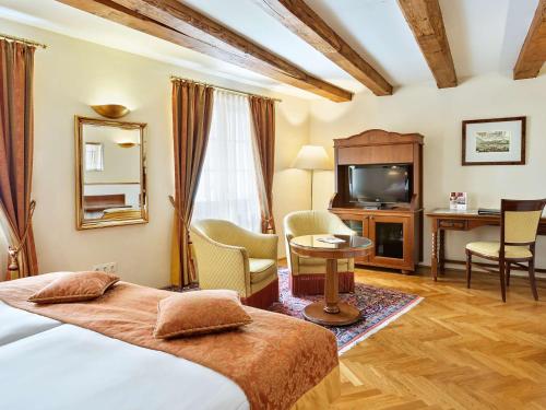 a hotel room with a bed and a television at Radisson Blu Hotel Altstadt in Salzburg